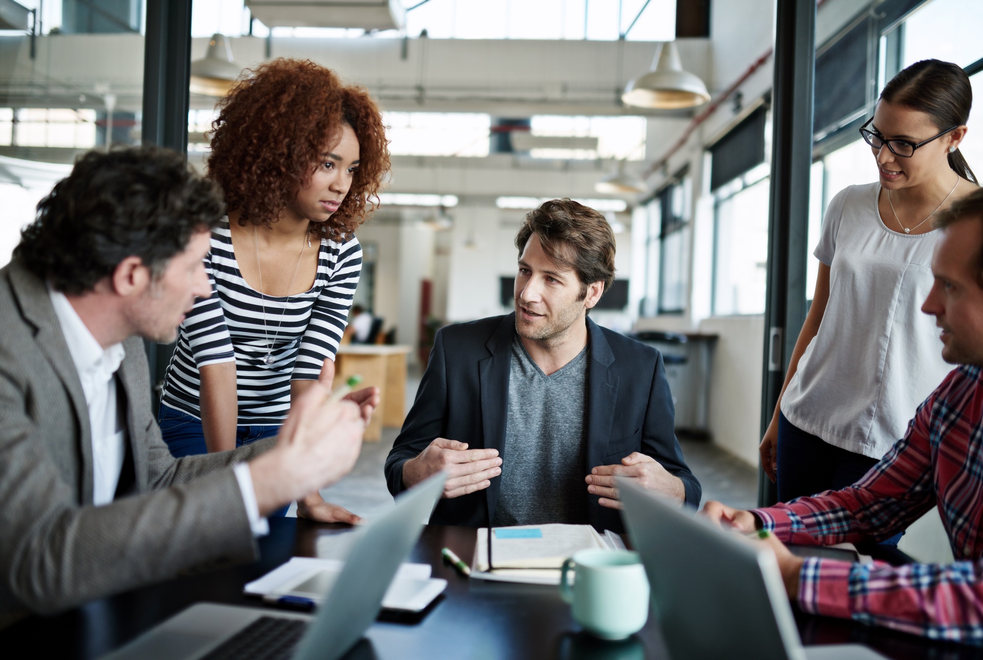 Getting a head start on the project. Shot of office workers talking in a meeting in an office.